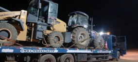 Guincho plataforma transportando um trator e uma retroescavadeira em Floriano, à noite.