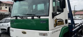 Guincho tipo plataforma estacionado em São Bento do Sul, com cabine branca e verde, sem veículo transportado visível.