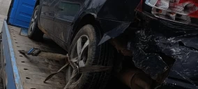 Veículo preto, com danos na traseira, transportado em guincho plataforma em Caruaru.