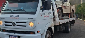 Guincho plataforma em Ivoti transportando um veículo utilitário de cor clara.