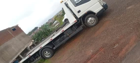 Guincho plataforma estacionado em rua de Bom Retiro do Sul, transportando carga não visível.