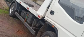 Guincho plataforma branco estacionado em área de terra em Bom Retiro do Sul.