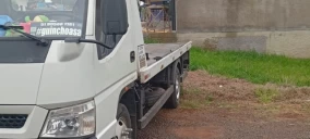 Guincho plataforma estacionado em área com grama, em Bom Retiro do Sul.