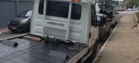 Guincho plataforma estacionado em Itaquaquecetuba, com veículos ao lado, sem carga visível.