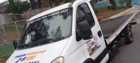 Guincho plataforma estacionado em rua de Itaquaquecetuba, com veículo não visível na parte traseira.