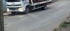 Guincho plataforma estacionado em rua de Juiz de Fora, sem veículo transportado visível.